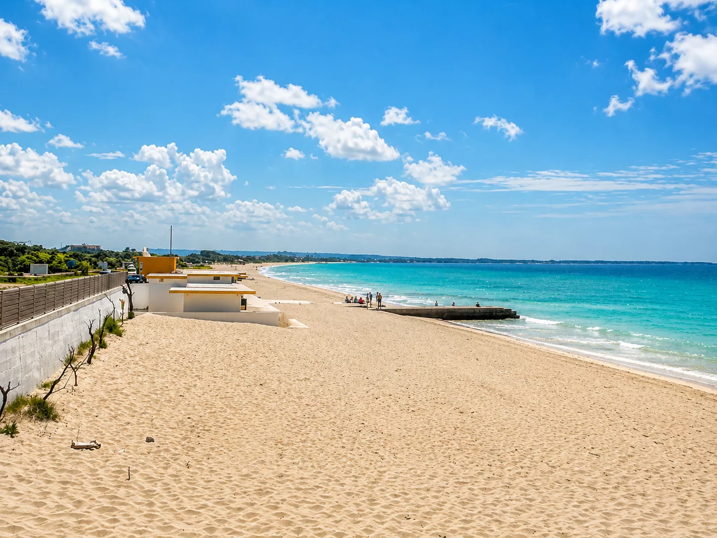 Ampia spiaggia sabbiosa di Baia Verde, bagnata da un mare limpido dalle tonalità turchesi.