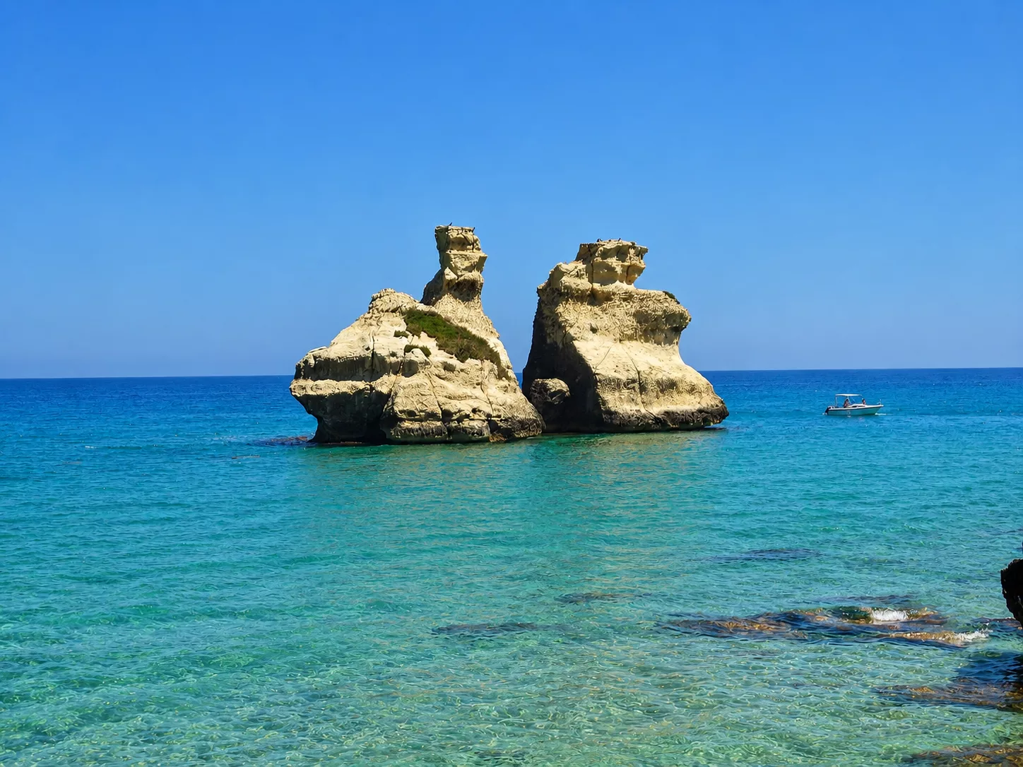 Le Due Sorelle di Torre dell’Orso emergono dal mare cristallino come uno dei simboli più celebri della costa adriatica salentina