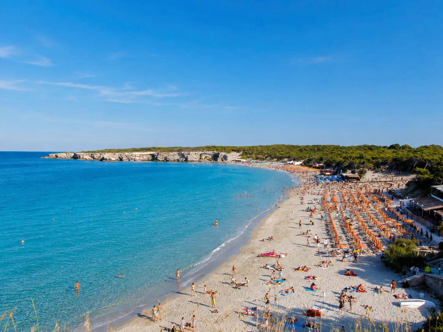 Veduta panoramica della baia di Torre dell’Orso, con spiaggia sabbiosa, mare cristallino e stabilimenti balneari.