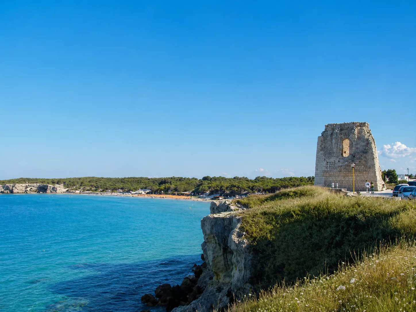 Veduta costiera di Torre dell’Orso con l’antica torre affacciata sul mare cristallino e sulla baia.